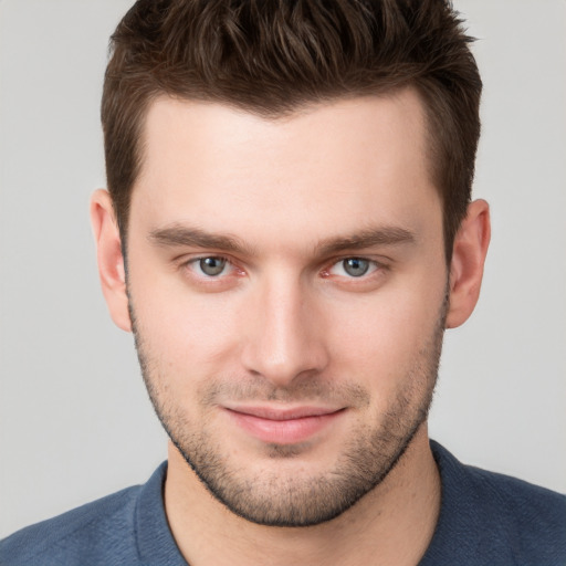 Joyful white young-adult male with short  brown hair and grey eyes