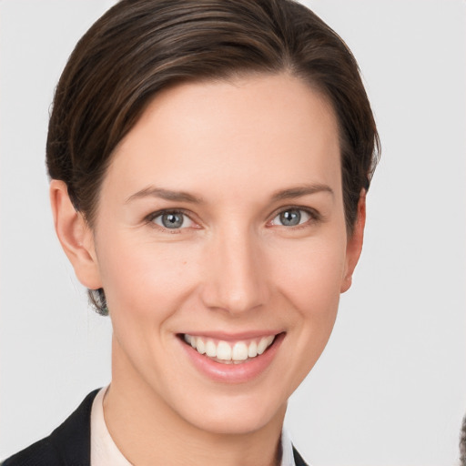 Joyful white young-adult female with short  brown hair and grey eyes