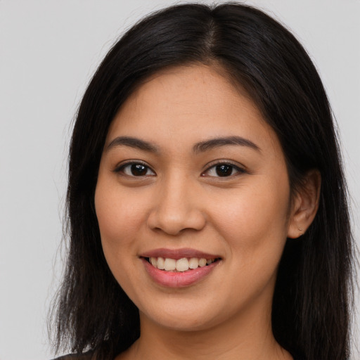 Joyful latino young-adult female with long  brown hair and brown eyes