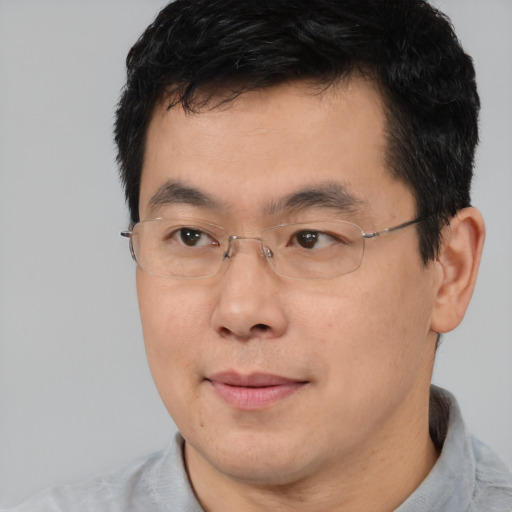 Joyful asian adult male with short  black hair and brown eyes