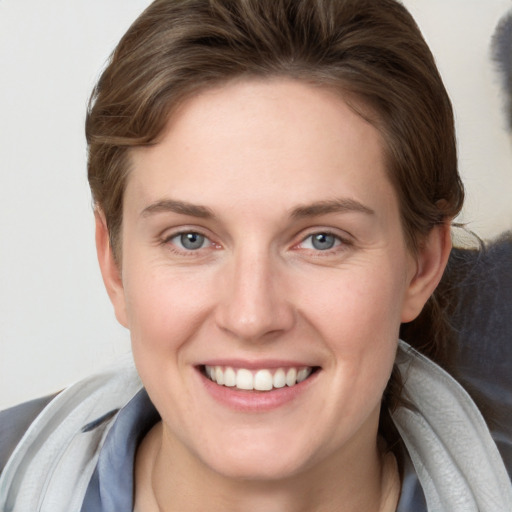 Joyful white young-adult female with short  brown hair and grey eyes