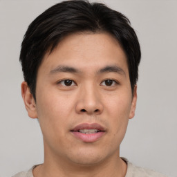 Joyful asian young-adult male with short  brown hair and brown eyes