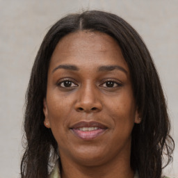 Joyful black young-adult female with long  brown hair and brown eyes