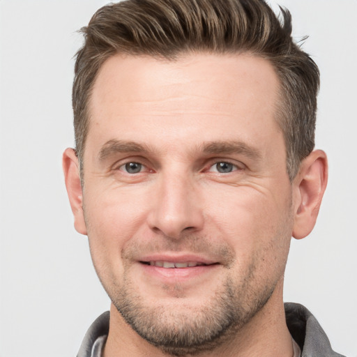 Joyful white adult male with short  brown hair and grey eyes