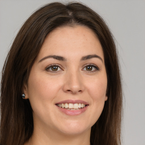 Joyful white young-adult female with long  brown hair and brown eyes