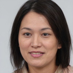 Joyful asian adult female with medium  brown hair and brown eyes