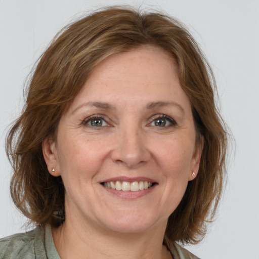 Joyful white adult female with medium  brown hair and grey eyes