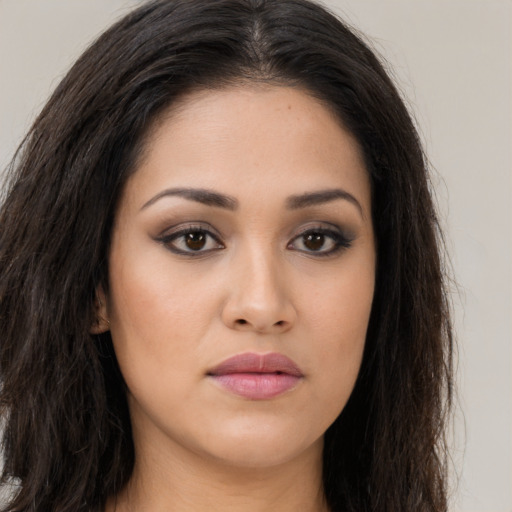 Joyful latino young-adult female with long  brown hair and brown eyes