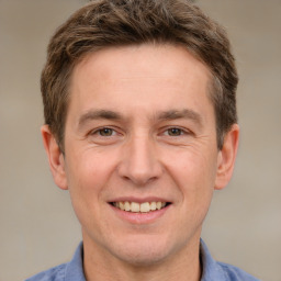 Joyful white adult male with short  brown hair and grey eyes