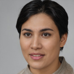 Joyful latino young-adult female with medium  brown hair and brown eyes