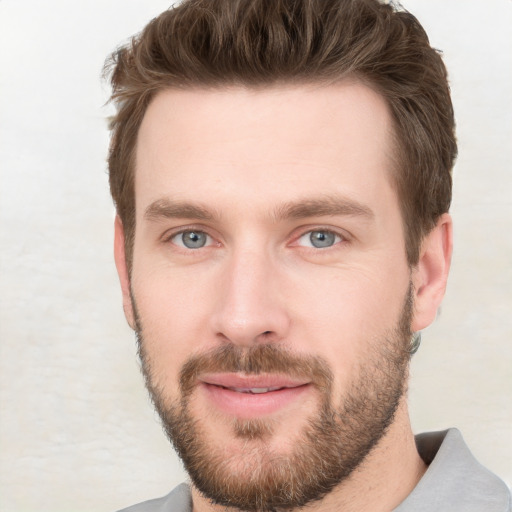 Joyful white young-adult male with short  brown hair and grey eyes