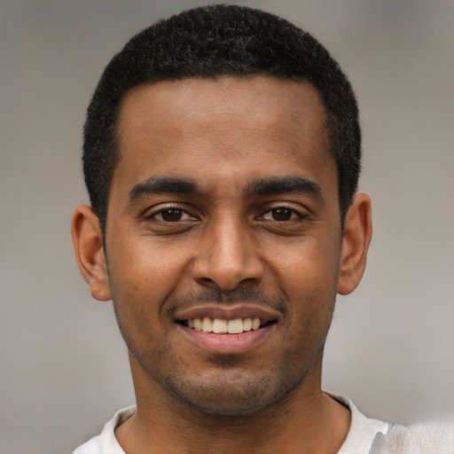 Joyful black young-adult male with short  black hair and brown eyes
