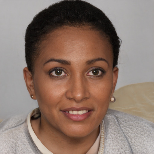 Joyful black young-adult female with short  brown hair and brown eyes
