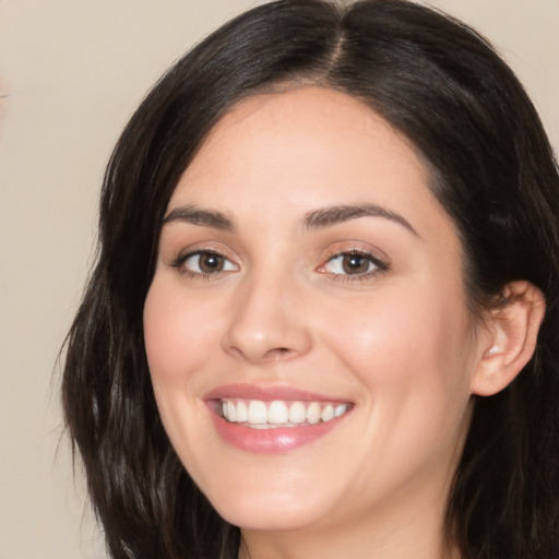 Joyful white young-adult female with long  black hair and brown eyes