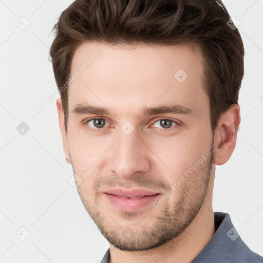 Joyful white young-adult male with short  brown hair and grey eyes