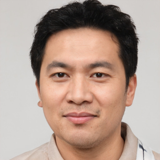 Joyful asian young-adult male with short  black hair and brown eyes