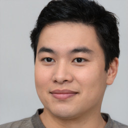 Joyful asian young-adult male with short  brown hair and brown eyes