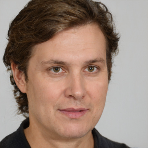 Joyful white adult male with medium  brown hair and brown eyes