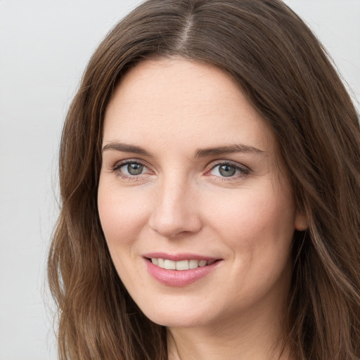 Joyful white young-adult female with long  brown hair and grey eyes