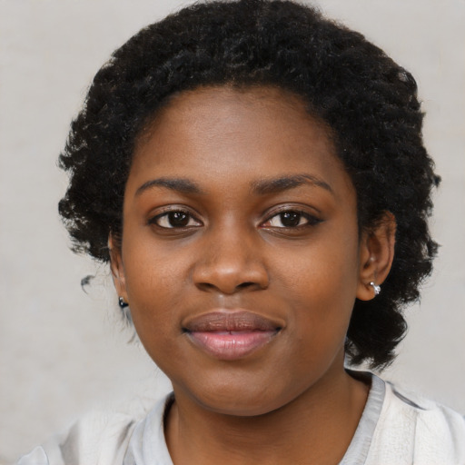 Joyful black young-adult female with short  black hair and brown eyes