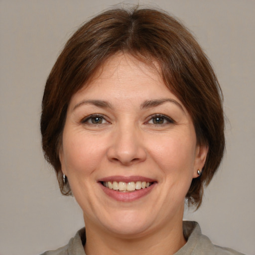 Joyful white adult female with medium  brown hair and brown eyes