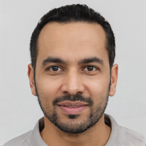 Joyful latino young-adult male with short  black hair and brown eyes
