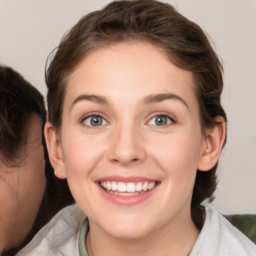 Joyful white young-adult female with medium  brown hair and green eyes