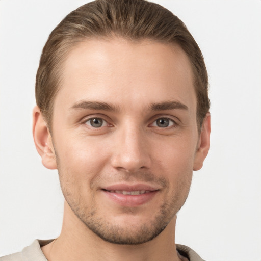 Joyful white young-adult male with short  brown hair and grey eyes