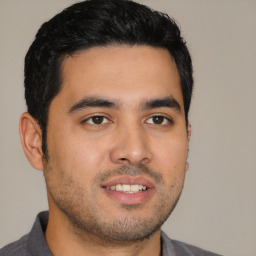 Joyful latino young-adult male with short  brown hair and brown eyes