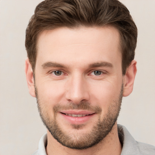 Joyful white young-adult male with short  brown hair and grey eyes