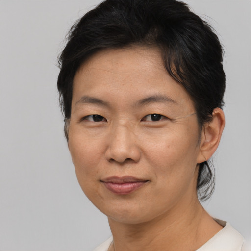 Joyful asian adult female with short  brown hair and brown eyes