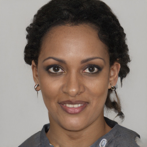 Joyful black young-adult female with short  brown hair and brown eyes