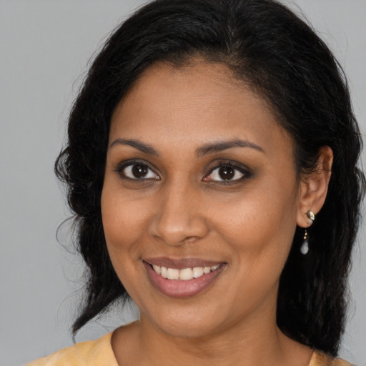 Joyful black young-adult female with medium  brown hair and brown eyes