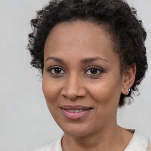Joyful black young-adult female with short  brown hair and brown eyes