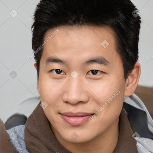 Joyful asian young-adult male with short  brown hair and brown eyes