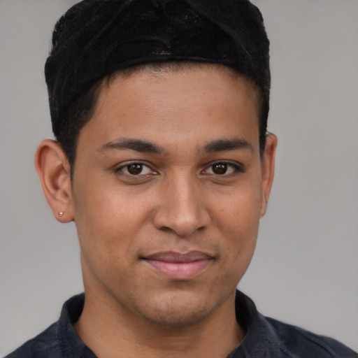 Joyful latino young-adult male with short  brown hair and brown eyes