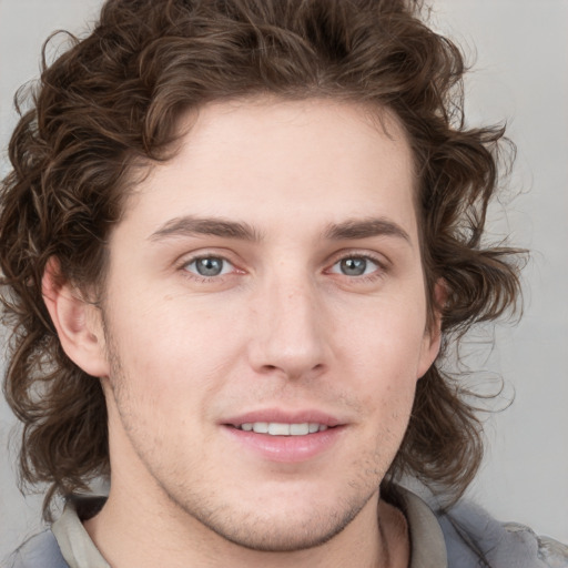 Joyful white young-adult male with medium  brown hair and blue eyes