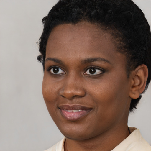 Joyful black young-adult female with short  brown hair and brown eyes
