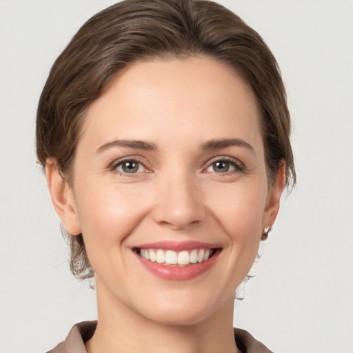 Joyful white young-adult female with medium  brown hair and grey eyes