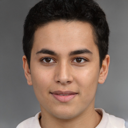 Joyful latino young-adult male with short  brown hair and brown eyes