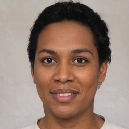 Joyful black young-adult female with short  black hair and brown eyes
