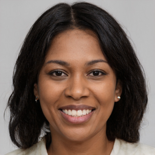Joyful black young-adult female with medium  black hair and brown eyes