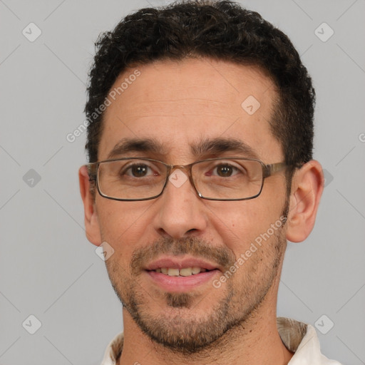 Joyful white adult male with short  black hair and brown eyes