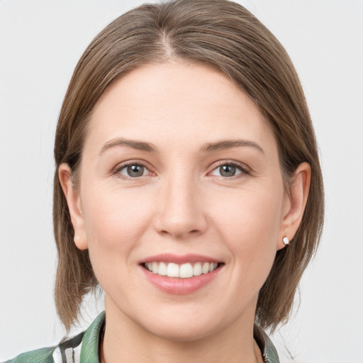 Joyful white young-adult female with medium  brown hair and grey eyes