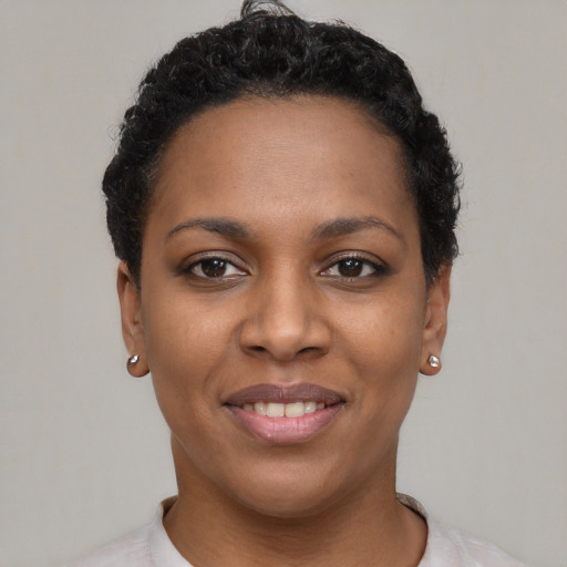 Joyful black young-adult female with short  brown hair and brown eyes