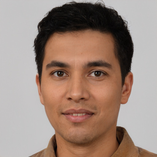 Joyful latino young-adult male with short  black hair and brown eyes