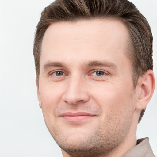 Joyful white young-adult male with short  brown hair and grey eyes