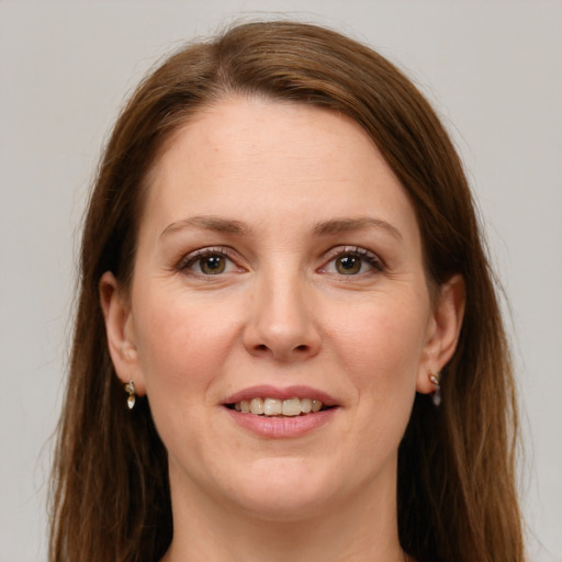 Joyful white adult female with long  brown hair and grey eyes