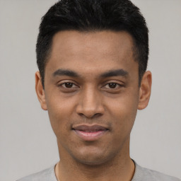 Joyful latino young-adult male with short  black hair and brown eyes