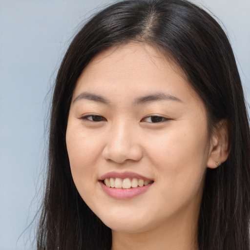 Joyful asian young-adult female with long  brown hair and brown eyes